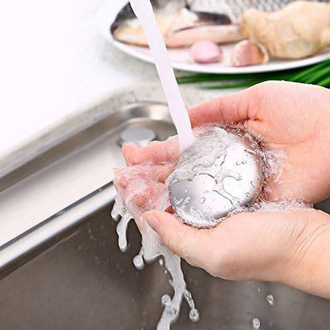Stainless steel odor remover soap with black base placed near kitchen sink. Ideal for eliminating garlic, onion, and fish smells from hands.