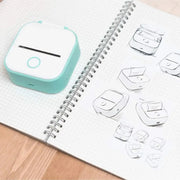 Portable Printer - Compact & Efficient design in white with teal trim, ideal for quick sticker printing on the go, shown with accessories.