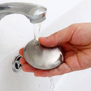 Stainless steel odor remover soap with black base placed near kitchen sink. Ideal for eliminating garlic, onion, and fish smells from hands.