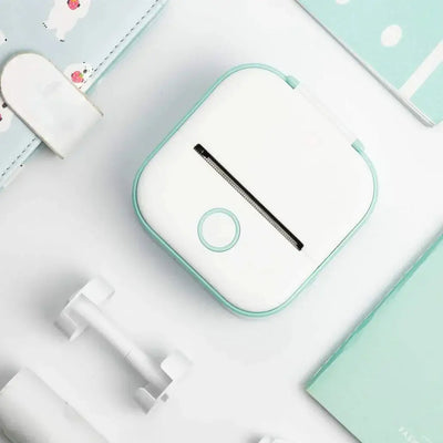 Portable Printer - Compact & Efficient design in white with teal trim, ideal for quick sticker printing on the go, shown with accessories.