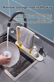 Adjustable telescopic sink rack in green and white, mounted over a kitchen sink, holding a towel, sponge, brush, and utensils for organized storage.